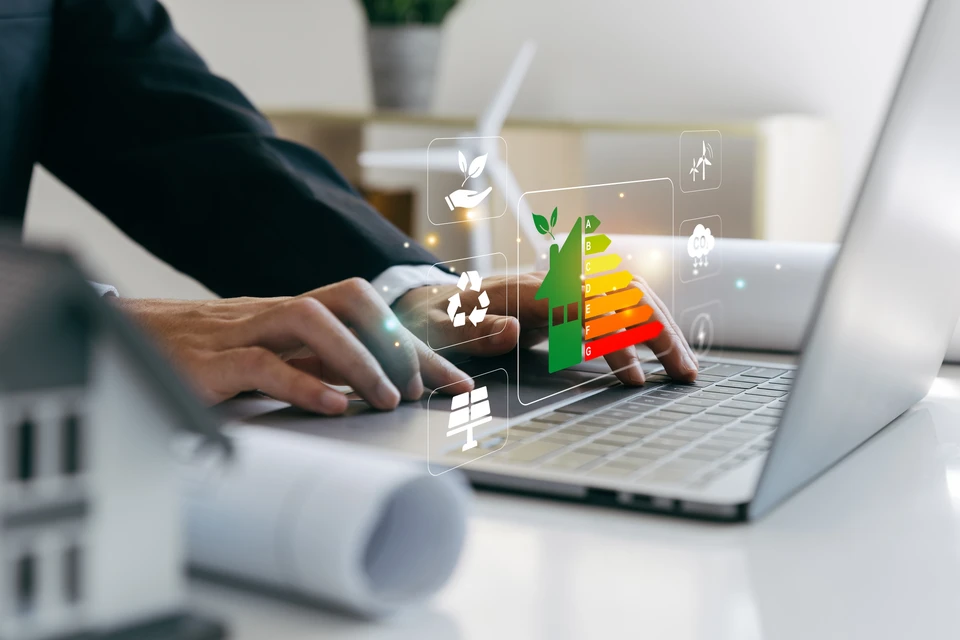 Concept d'amélioration de l'habitat, Main d'homme d'affaires utilisant un ordinateur portable avec la cote d'efficacité énergétique, maison écologique et bioénergétique, échelle d'efficacité