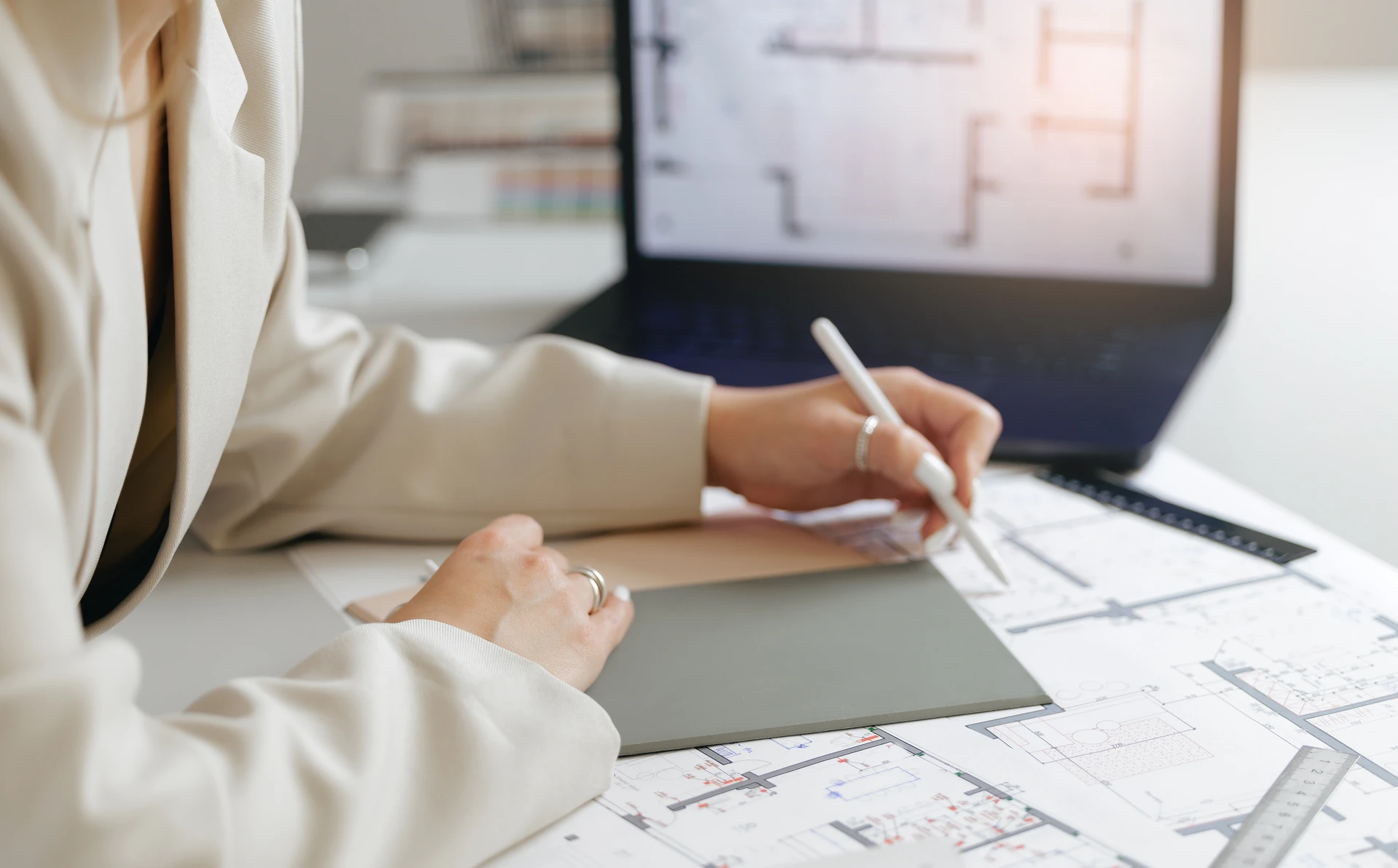 Professionnel d'audit énergétique en costume professionnel examinant attentivement les plans d'une copropriété au cours d'une réunion de travail, assis à un bureau avec des documents techniques, stylo à la main, illustrant l'analyse rigoureuse et le conseil neutre fourni par le bureau d'études.